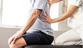 a physiotherapist relieving back pain from a patient