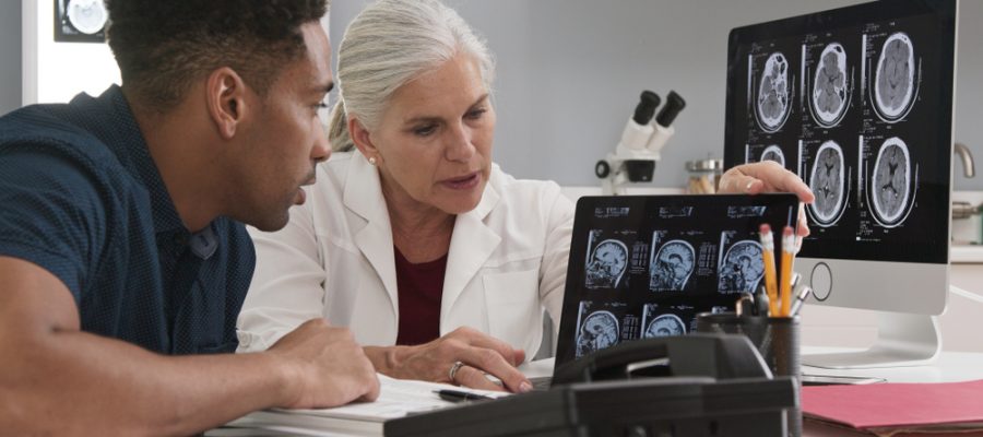 A patient and healthcare provider review brain scan results