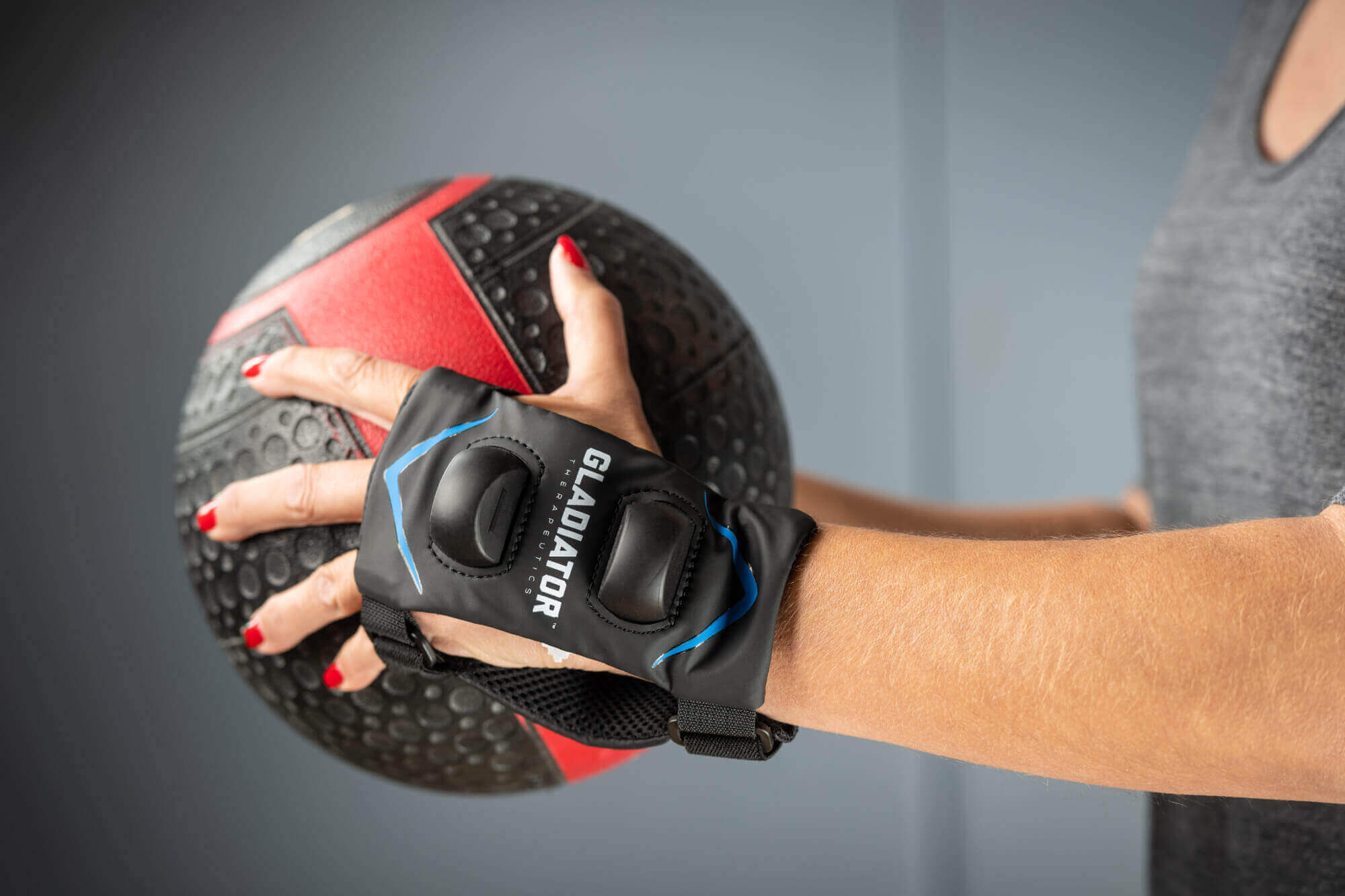 Gladiator Therapeutics Wrist Device Woman with a gladiator wrist device holding a medicine ball